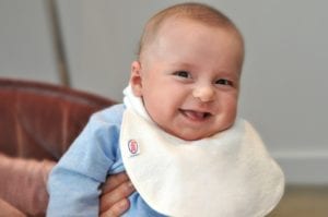 smiling baby with a Bibby bib