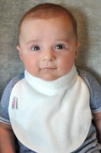 a baby wearing a Bibby bib looking up