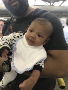 a father holding a baby wearing a Bibby bib